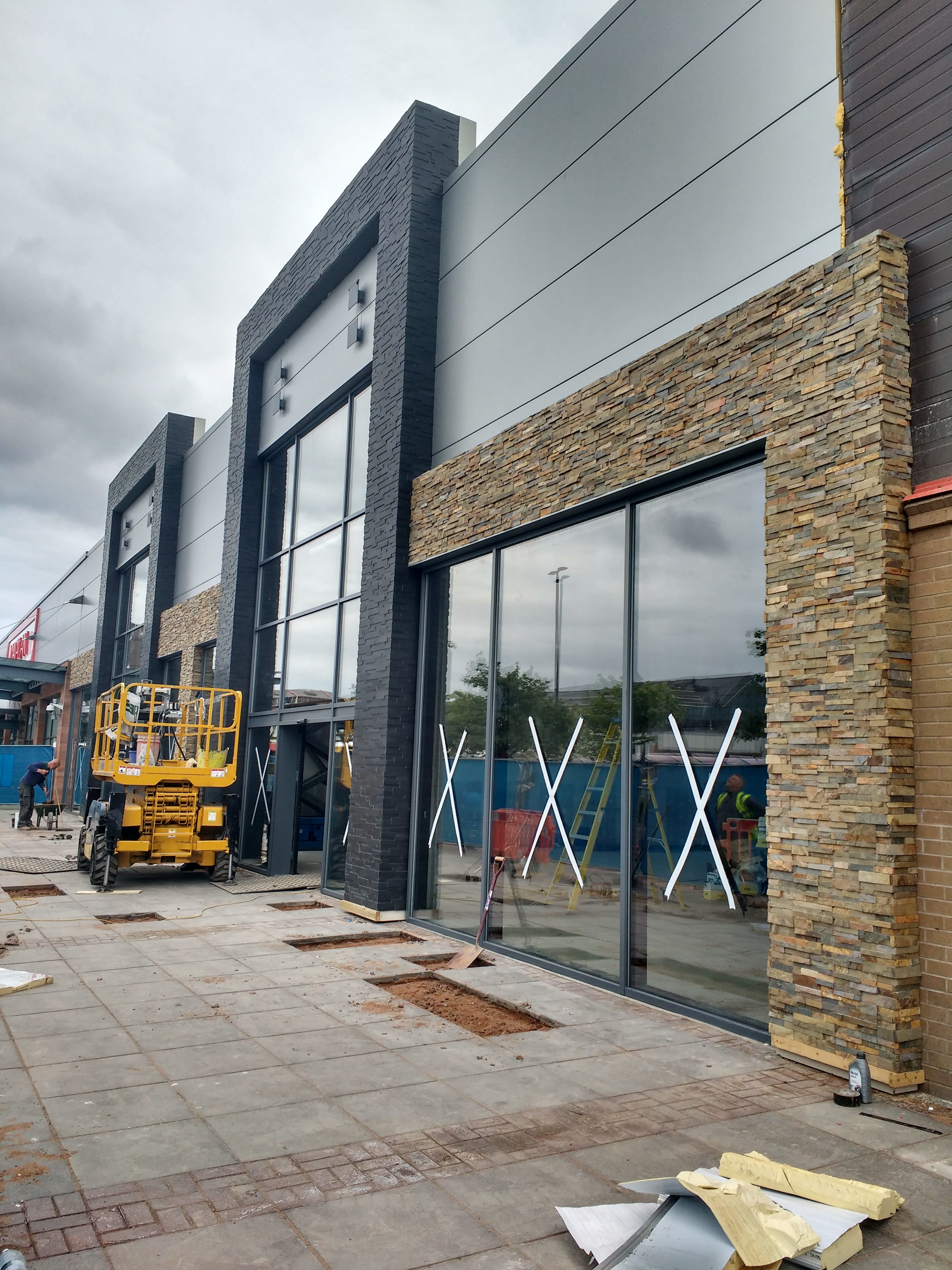 Commercial Entryway under construction where Norstone Ebony Aksent 3D Panels and Ochre XL Series Rock Panels were used